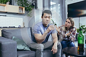 Asian husband is an alcoholic, drinks strong alcohol at home, his wife quarrels with him and tries to interfere, multiracial