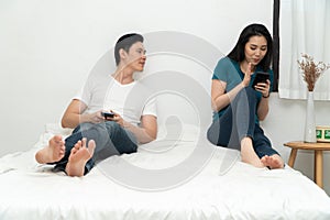 Asian husband feeling suspicious of my wife`s abnormality in smartphone use and his wife ignores him and uses the smartphone all