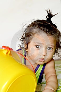 An Asian Indian baby boy of age 7 months playing