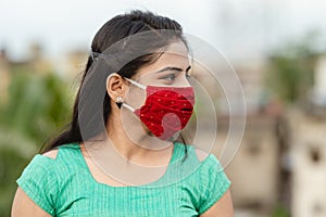 Asian / Indian woman wearing face mask against Pollution, Coronavirus or COVID-19