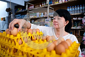 Asian Indonesian women arranging eggs inside small local family-owned business store, locally called warung. Selective Focus photo