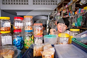 Asian Indonesian women in front of small local family-owned business store, locally called warung. Selective Focus photo