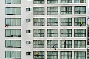 Asian industrial worker cleaning windows of a modern building