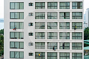 Asian industrial worker cleaning windows of a modern building