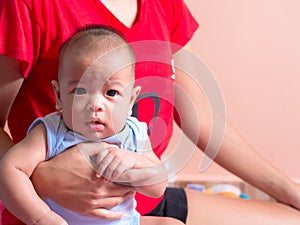 Asian infant in mother arms.