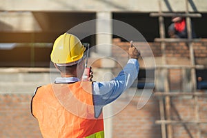 Asian inspector checking structure of new property and taking note in the clipboard for review and fix the house before sell.