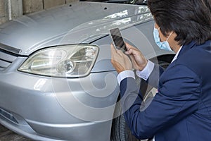 Asian Insurance Agent or Insurance Agency Wear Mask Take Car Crash Photo