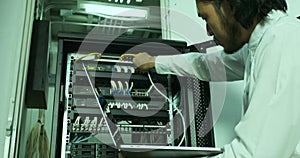 Asian internet technician checking modem cabinet.