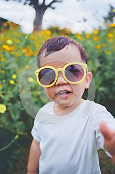 Asian Japanese little child boy wearing yellow sunglasses