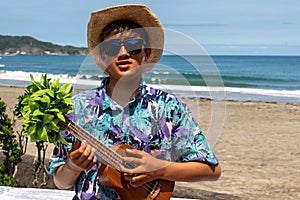 Asian, Japanese teenager playing the Ukulele on a beach in Chiba Japan
