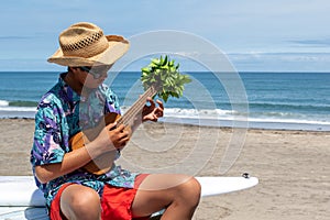 Asian, Japanese teenager playing the Ukulele on a beach in Chiba Japan