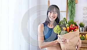 Asian Japanese woman holding shopping bag from supermarket full of organics vegetables and fruits for healthy food and vegetarian