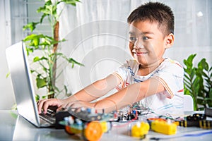 Asian kid boy learns coding and programming with laptop for Arduino robot car