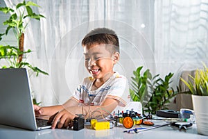 Asian kid boy learns coding and programming with laptop for Arduino robot car