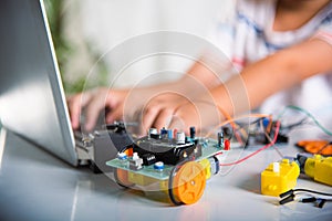 Asian kid boy learns coding and programming with laptop for Arduino robot car