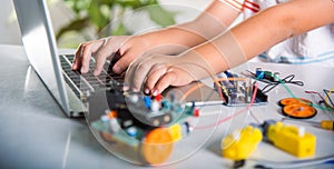 Asian kid boy learns coding and programming with laptop for Arduino robot car