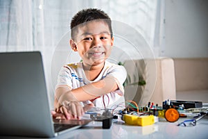 Asian kid boy learns coding and programming with laptop for Arduino robot car