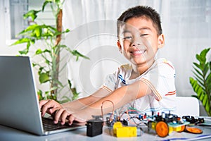 Asian kid boy learns coding and programming with laptop for Arduino robot car
