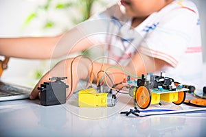 Asian kid boy learns coding and programming with laptop for Arduino robot car