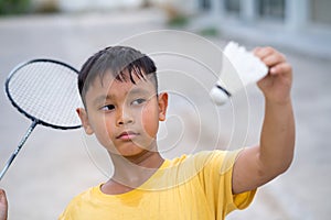 Asian kid boy playing badminton at home