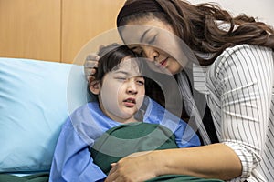 Asian kid is crying while having treatment for her illness in the hospital with mother giving support to calm her down