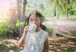 Asian kid drinking indoor, natural green.