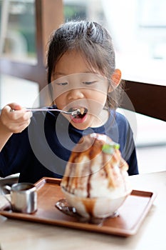 Asian Kid Enjoys Eating Shave Ice Frozen Dessert