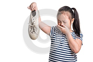 Asian kid girl age 7 year hold stinky shoe on white background