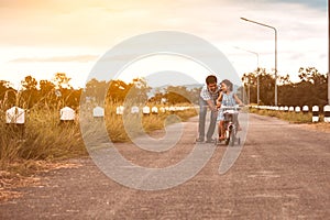 Asian kid girl having fun to ride bicycle with father