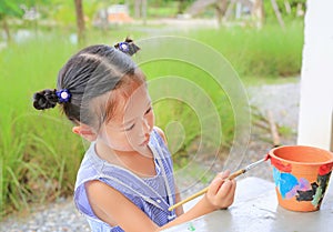 Asian kid girl paint on earthenware dish