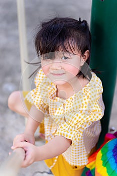 An Asian kid girl plays and clamber in the playground. photo
