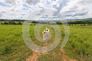 Asian kid and her mother standing and enjoying with beautiful nature in tropical forest.