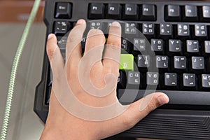 Asian kid left hand and use his finger to press on gaming keyboard
