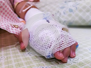 Asian kid patient, Close up of iv plug in patient`s child hand.heparin lock in hospital with saline intravenous IV drip