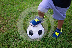 Asian kid playing soccer or football in the park. photo