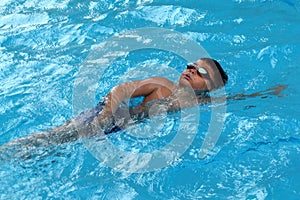 Asian kid swims in swimming pool - front crawl style take deep breath