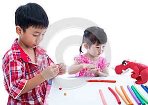 Asian kids playing with play clay on table. Strengthen the imagi