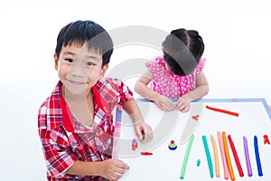 Asian kids playing with play clay on table. Strengthen the imagination photo