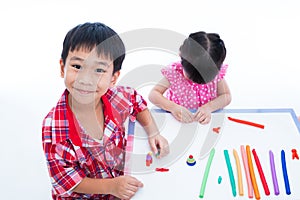 Asian kids playing with play clay on table. Strengthen the imagination