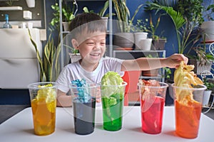 Asian kindergarten boy having fun making Rainbow Cabbage Experiment, Kid learn about how plants thrive by pulling water through photo