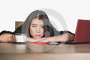 Asian Korean business woman working in stress at office computer desk feeling overwhelmed and frustrated suffering depression thin