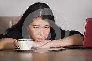 Asian Korean business woman working in stress at office computer desk feeling overwhelmed and frustrated suffering depression thin