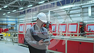 Asian, Korean chinese professional male engineer in hard hat using digital tablet