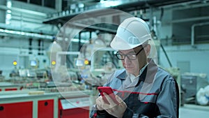 Asian Korean professional male engineer in hard hat using mobile phone smartphone