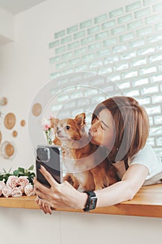 Asian Korean woman playing with her dog and taking selfie