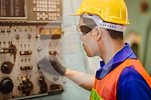 Asian labor worker hard working with control safety machine in metal factory industry