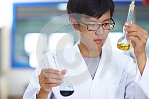 Asian Laboratory scientist working at lab with test tubes