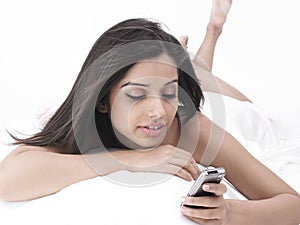 Asian lady in bed with cell phone