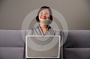 Asian lady in business attire, using a computer photo