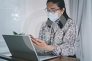 Asian lady businesswoman wearing mask for protect coronavirus to work from home communicate by conference video call on laptop,
